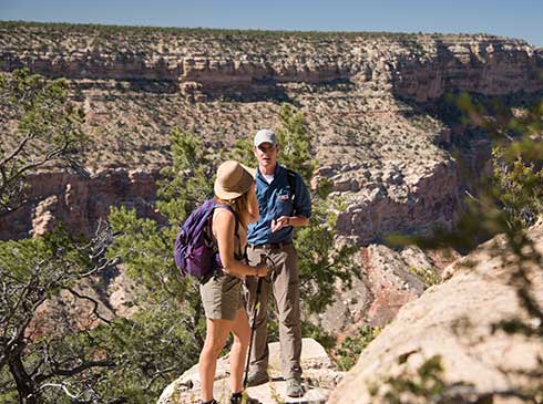 Pink® Jeep® tour guide and client standing along the edge of the Grand Canyon's Hermit Trail.