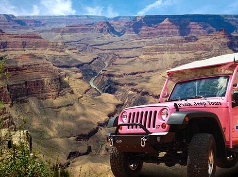 Pink® Jeep® parked in front of panoramic view of the Grand Canyon with Colorado River below