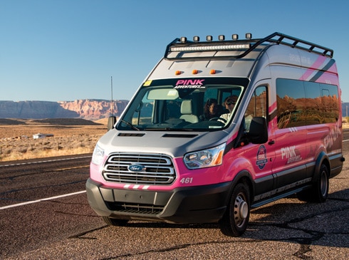 Pink Adventure Tours' Adventure Tour Trekker parked along the road with Arizona desert landscape in background.
