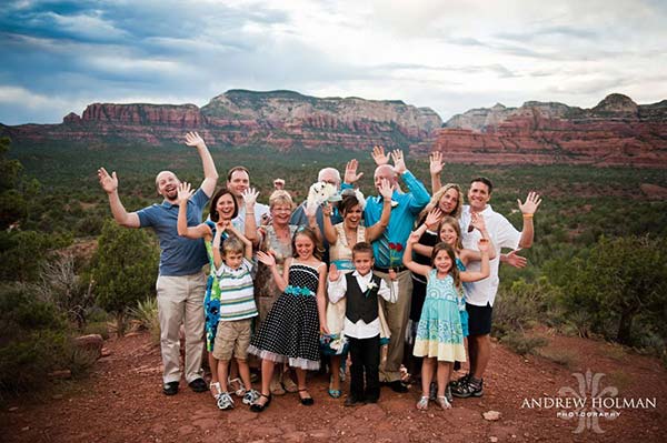 Newlyweds and family laughing and posing at Dry Creek Vista First Overlook with Red Rock-Secret Mountain Wilderness in the distance