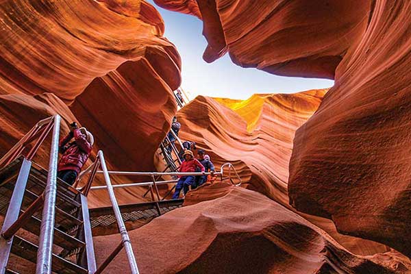 Visitors descending stairs into Lower Antelope Canyon