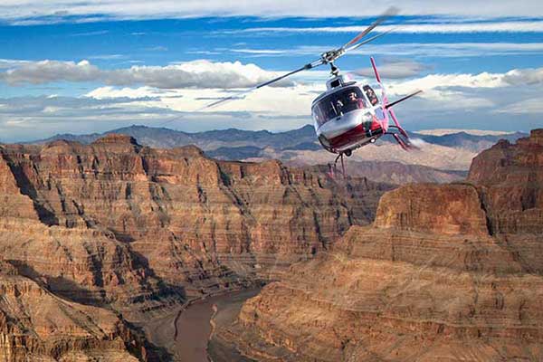 Helicopter soaring over Grand Canyon with beautiful blue sky