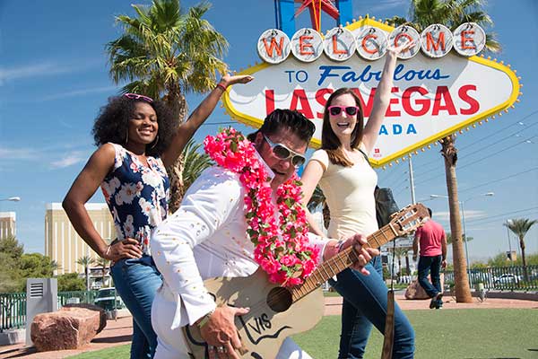 Two girls posing with Elvis by Welcome Las Vegas sign