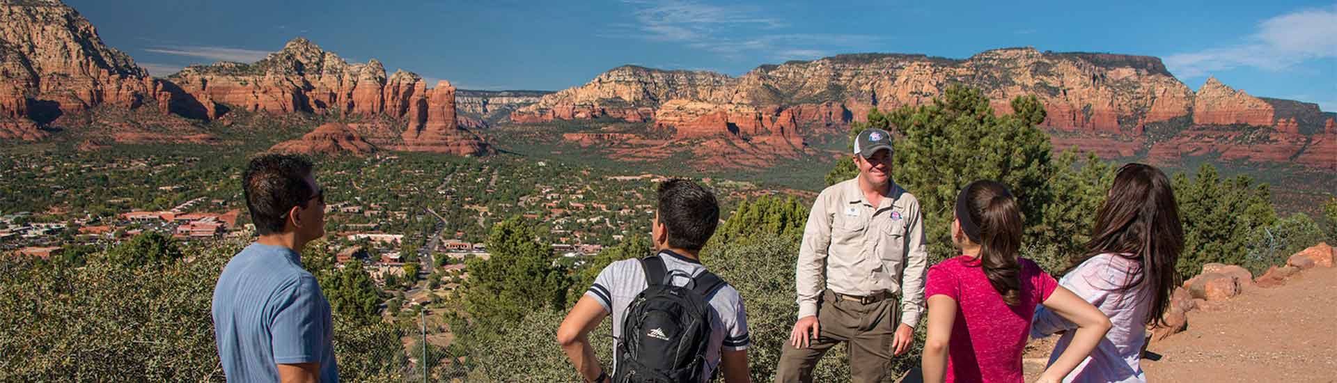 Pink Jeep guide and family on Sedona 360 Tour overlooking the town and red rocks from Airport Mesa Overlook