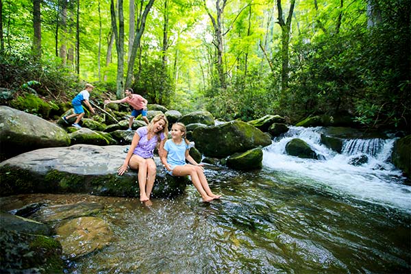 Family playing in mountain stream along the Roaring Fork Motor Nature Trail, GSMNP
