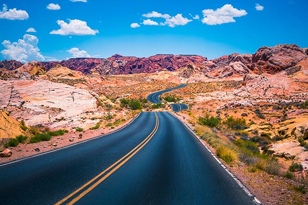 Vibrant view of White Domes Road winding towards red rock formations of Valley of Fire State Park, Nevada