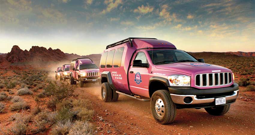 Pink Adventure Tour Trekkers driving through Nevada desert on a large youth group tour.