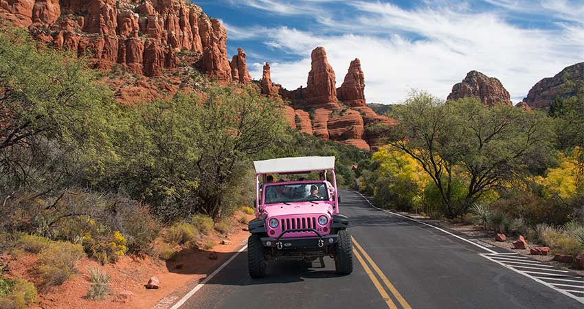 Pink Jeep Wrangler with wedding guests touring Red Rock Country in Sedona, AZ