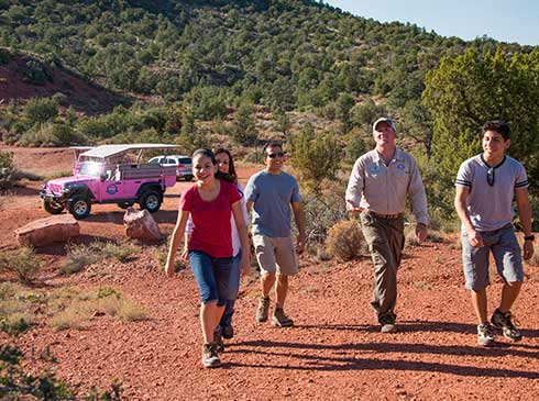 Pink® Jeep® guide and family of four walking up hill to Mystic Mesa on the tranquil Touch the Earth tour