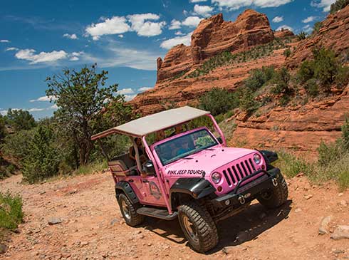 A custom-built, open-air Pink® Jeep® climbs Schnebly Hill Road through Sedona's rugged backcountry.