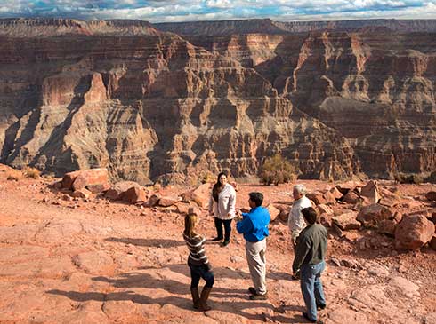 Pink® Jeep® tour guide explaining Grand Canyon West Rim view to guests