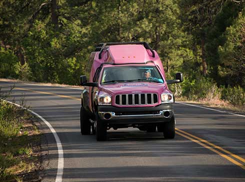 Front view of Pink Jeep Tour Trekker driving up Oak Creek Canyon, Grand Canyon South Rim tour
