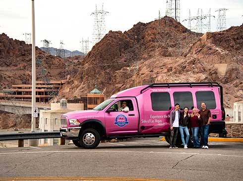 Group photo of tour guests in front of Pink® Jeep® Tour Trekker at Hoover Dam