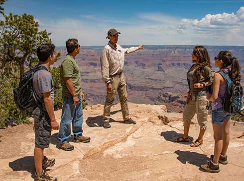 Pink® Jeep® professional guide explaining Grand Canyon geology to guests at an overlook point