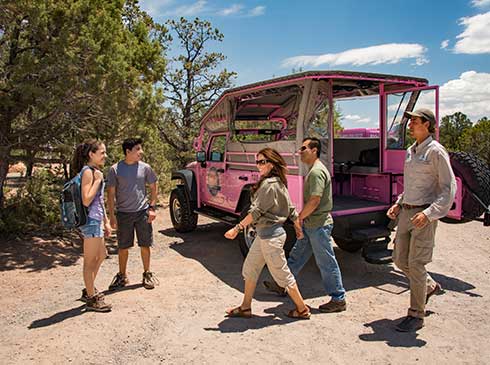 Family of four and Pink® tour guide walking past custom Jeep® Wrangler while stopped at Grandview Point