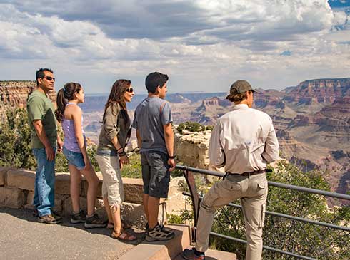 Pink Jeep Tours guide and family of four looking out over the Grand Canyon South Rim.