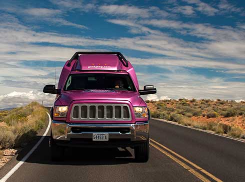 Front-end view of Pink Jeep Tour Trekker traveling through Mohave Desert en route to Grand Canyon West Rim