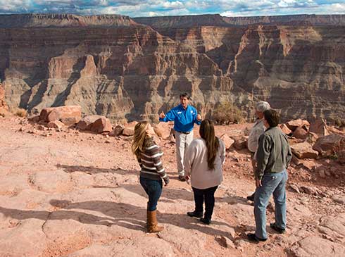 Pink® Jeep® tour guide talking with guests overlooking the Grand Canyon West Rim