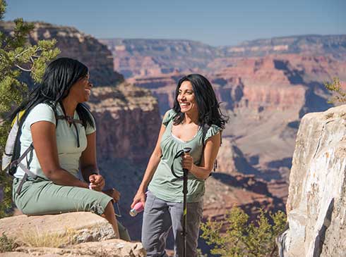 Two women resting along the Hermit Trail with the Grand Canyon views in background.