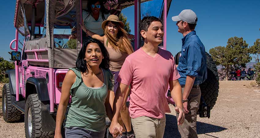 Hermits Rest Tour passengers exiting the rear of a custom Pink® Jeep® vehicle at the Grand Canyon.