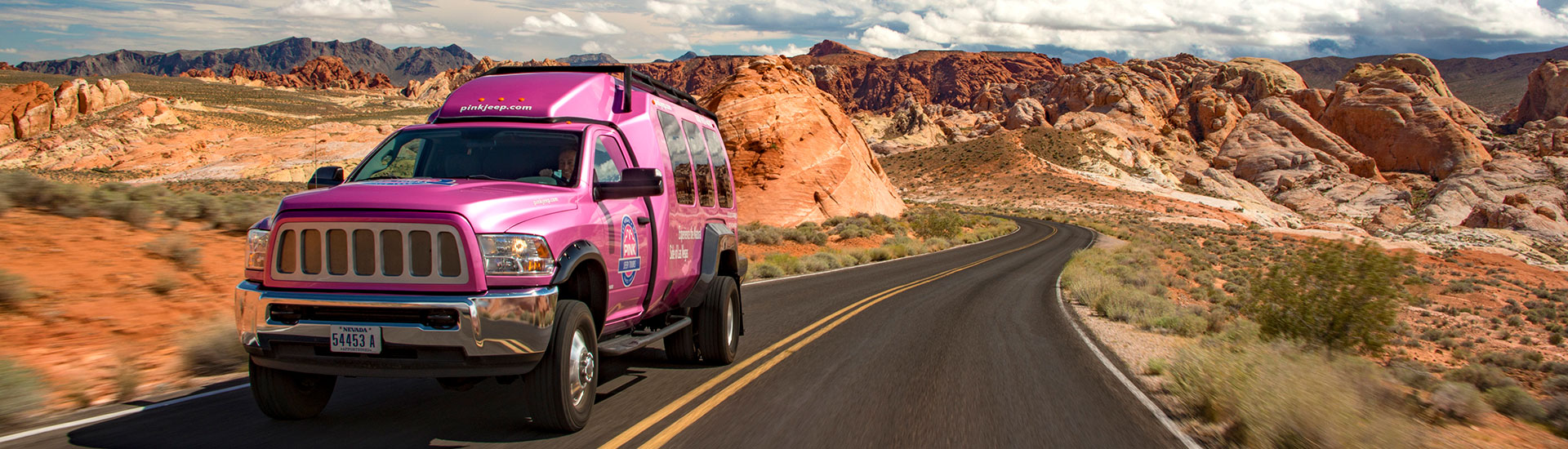 Pink Jeep Adventure Tour truck driving through the desert