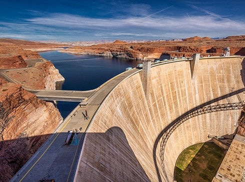 Aerial view of Glen Canyon Dam and Lake Powell on a summer day in the Arizona desert, USA.