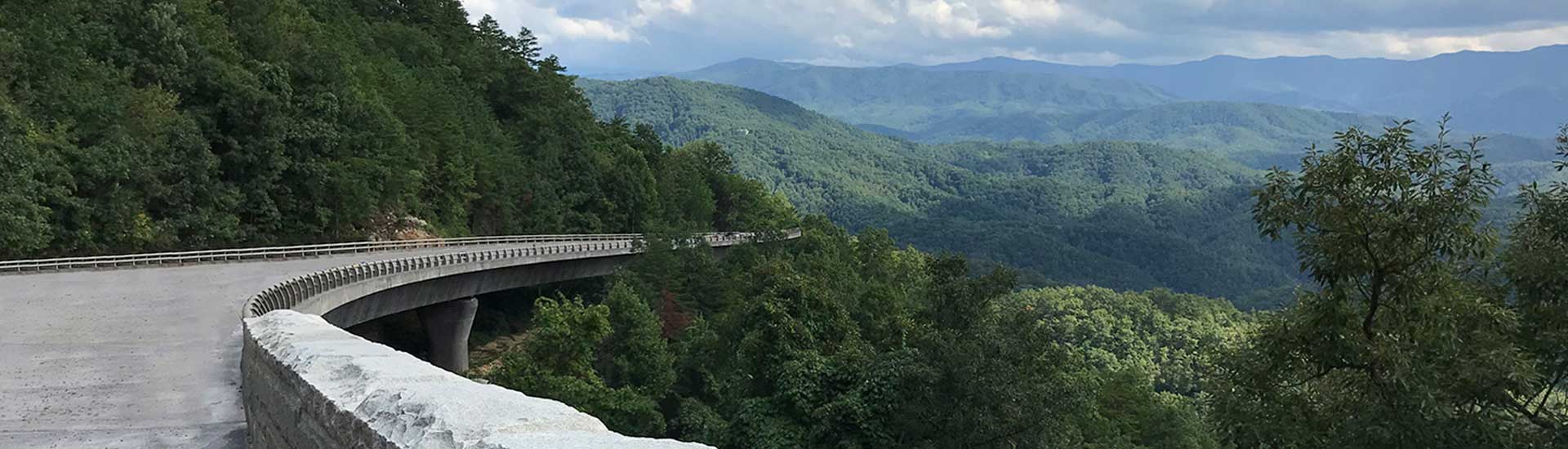 Valley view of green trees and blue ridges of Great Smoky Mountains from Foothills Parkway bridge, GSMNP