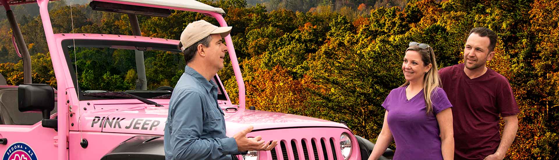 Pink Jeep Tours certified guide talking with couple by jeep on Smoky Mountains Foothills Parkway tour in autumn.
