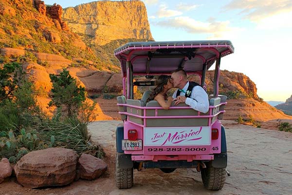 Newlyweds kissing in backseat of Pink Jeep with Just Married sign at Chicken Point in Sedona, AZ