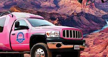 Pink Jeep Tour Trekker side frontal view with Grand Canyon and Colorado River in background.