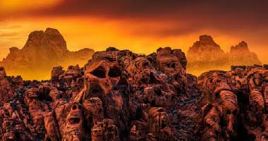 Fiery landscape of the Devils' Golf Course with jagged skull-like salt formations in Death Valley National Park.