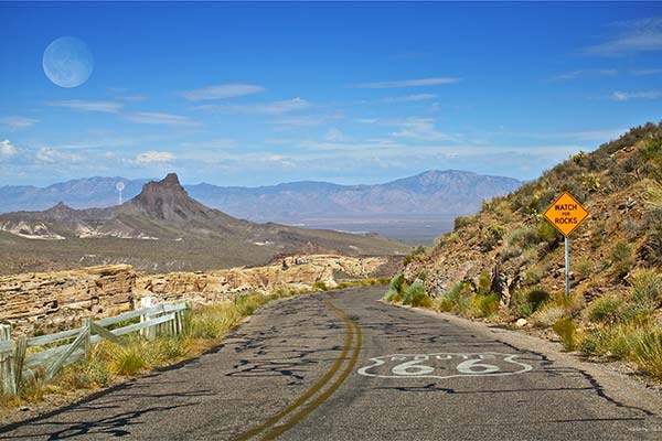 Highway Route 66 in southwest landscape with blue sky moon