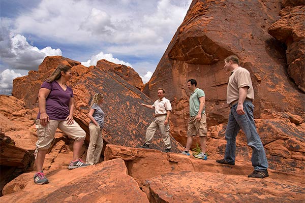 Pink Jeep Tour guide explaining petroglphys to tour guests at Valley of Fire State Park