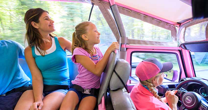 Mother and daughter seated in back of Pink Jeep with guide driving the Newfound Gap tour, GSMNP
