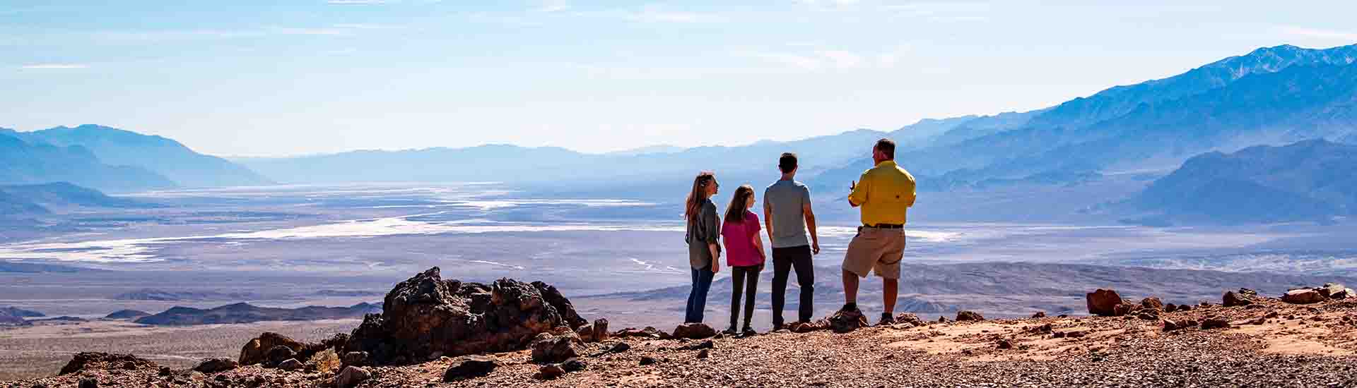  Pink Adventure Tour guide and guests standing on hill, looking out over salt flats at Death Valley National Park