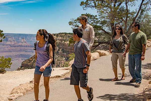 Pink Adventure Tour guide and family of four walking the paved trail along Grand Canyon's South Rim