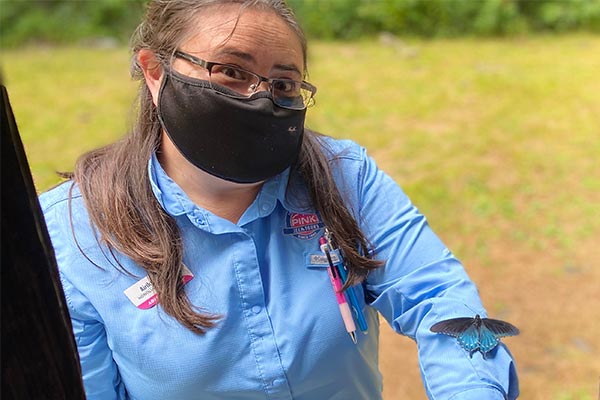 Smoky Mountains adventure guide Airika White displaying a blue butterfly resting on her arm.