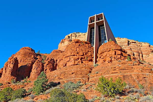 The Chapel of the Holy Cross set among red rocks in Sedona, Arizona against a vibrant blue sky.