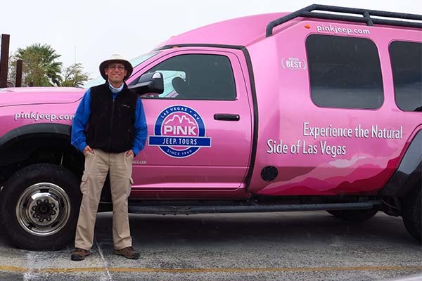 Chris Meyers, Pink Jeep Tours Las Vegas Adventure Guide standing beside a Pink Adventure Tour Trekker.