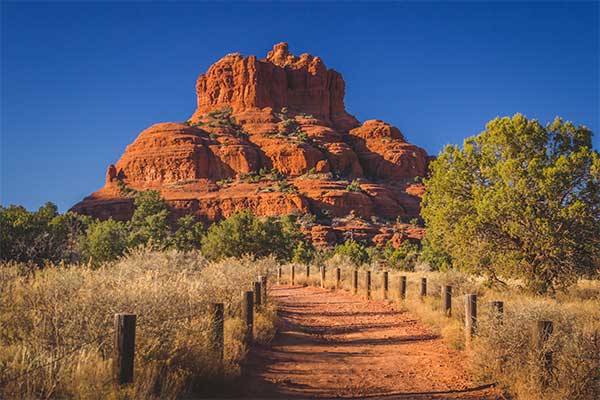 The Bell Rock Loop Trail leading up to Bell Rock, poised against a deep blue sky in Sedona, AZ.