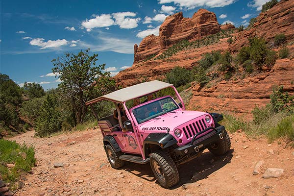 Tour guide and guests climbing Schnebly Hill Road in Pink® Jeep® Wrangler on the Scenic Rim Tour, Sedona, AZ.