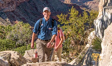 A Pink Adventure Tour Guide leads hikers up the Hermit Trail at the Hermits Rest Overlook at the Grand Canyon South Rim, Arizona.