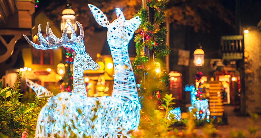 Warmly lit Christmas plaza with brilliant, white light deer sculptures and holiday decorations in the Great Smoky Mountains, TN.