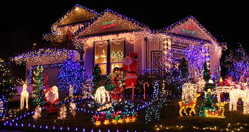 Brilliant Christmas lights display of home with Santa and reindeer scene out front, Pigeon Forge Christmas Light, Pink Jeep Tours. 