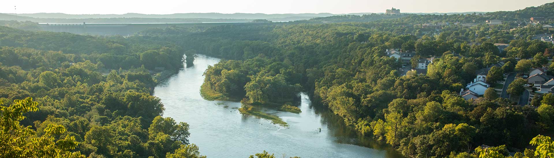 Looking down on Lake Taneycomo from the Branson 165 Scenic Overlook, with a warm hazy sky.