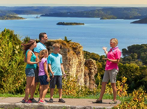 Pink® Jeep® Tours Branson tour guide talking with guests at Baird Mountain viewpoint overlooking Table Rock Lake.