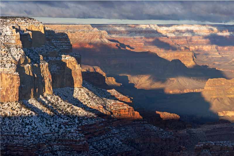 Morning light dances over the landscape at Maricopa Point, with the Grand Canyon’s walls lightly dusted in snow.
