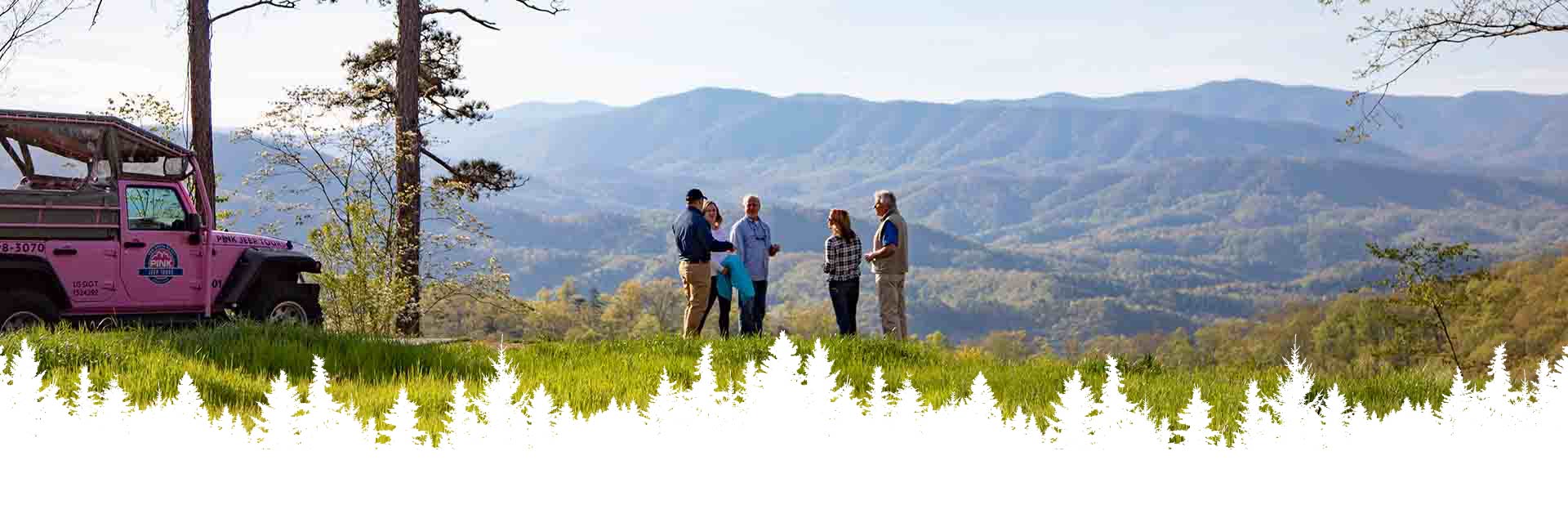 A Pink Jeep Foothills Parkway adventure guide with guests overlooking an expansive view of Smoky Mountains, with a custom Pink Jeep parked nearby.