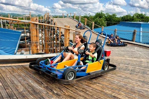 Mother and son driving a go-kart on the high-rise Lumber Jack track in Branson, Missouri.