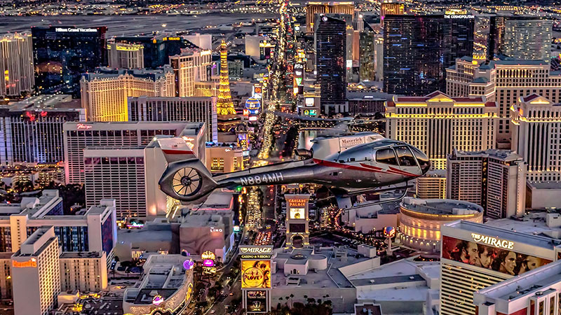 Maverick Helicopter flying over Las Vegas skyline at night on Pink Jeep's Land Air See tour.